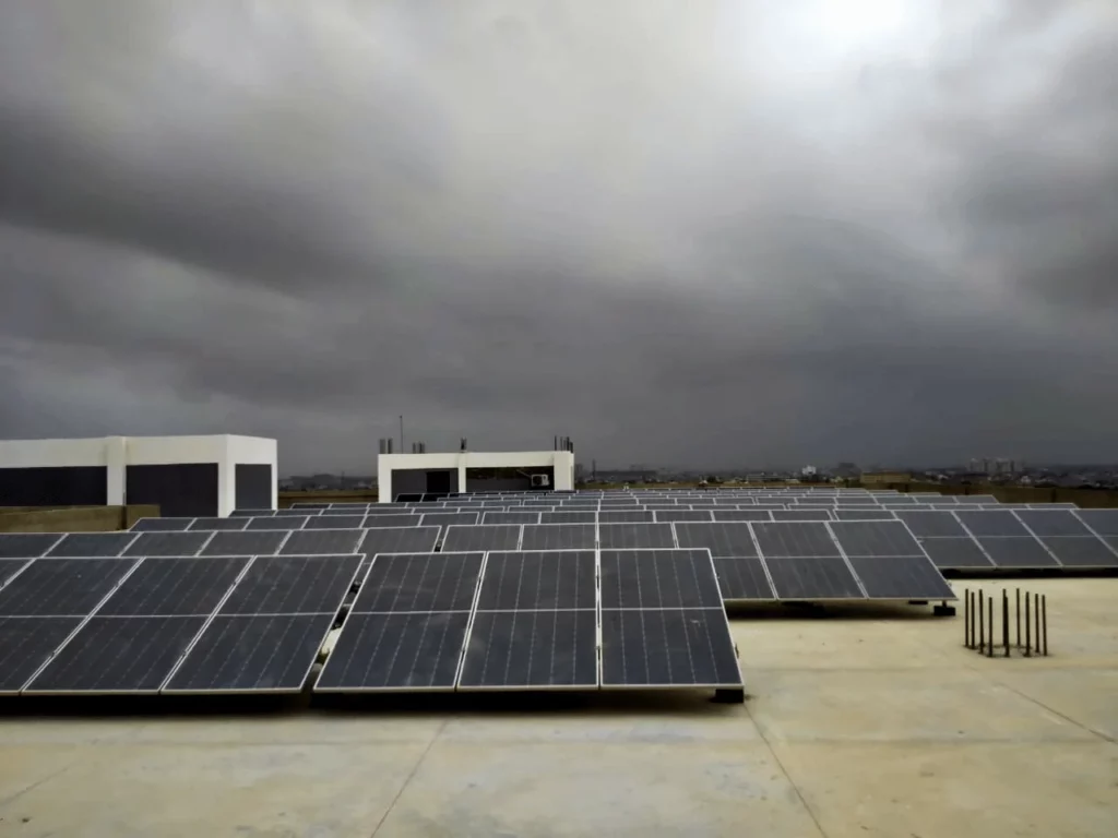 Blue solar panel array with dark clouds installed at a towel mill in Karachi